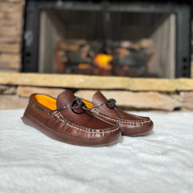 Blair's leather moccasins by a fireplace