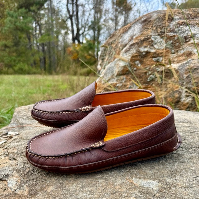 Brown leather loafers on a rock with a natural background