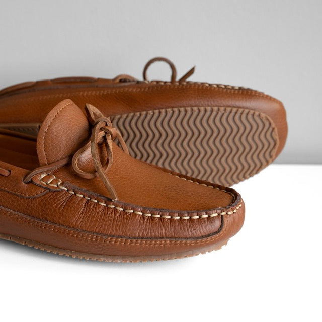 Brown leather moccasin shoes on a white background