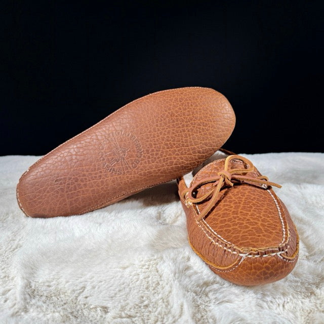 Brown leather shoes on a white surface with a black background