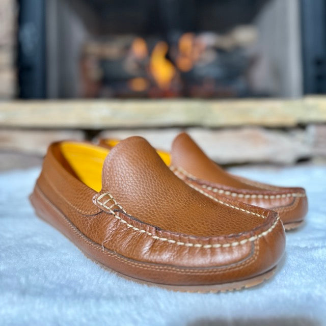 Sam's leather moccasins by a fireplace