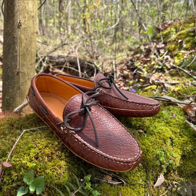 Brown leather shoes on a mossy forest floor